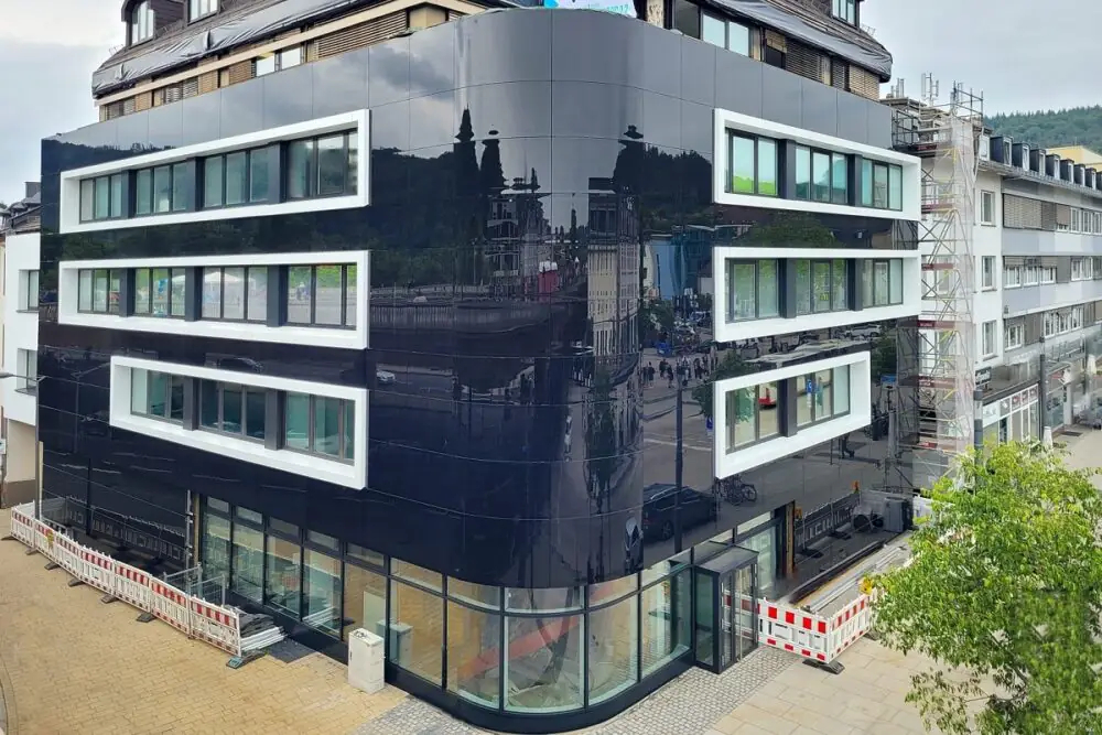 Sanierung eines Bestandbaus mit gewölbter Fotovoltaik-Fassade